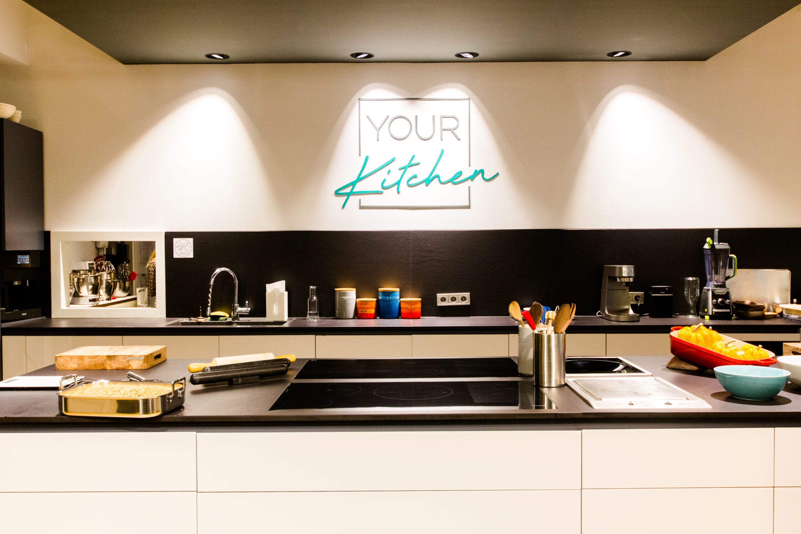 Firmenevent in YOUR Kitchen: lange Tafel, Gäste und Private Chefs an der Showküche